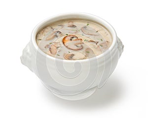 Cream of mushroom soup in a white tureen isolated on a white background