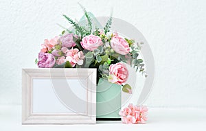 Cream photo frame mock up, pink roses on light background. Floral festive photo. Cozy home interior with flowers
