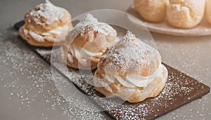 Cream puffs sprinkled with powdered sugar. Sweet dessert