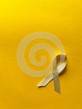 Cream ribbon on yellow background, cancer awareness, World Cancer Day