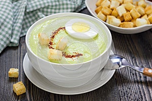 Cream soup with avocado, garnished with egg and croutons