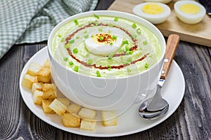 Cream soup with avocado, garnished with egg and croutons