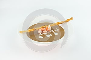 Cream soup with crab meat and bread stick on white background