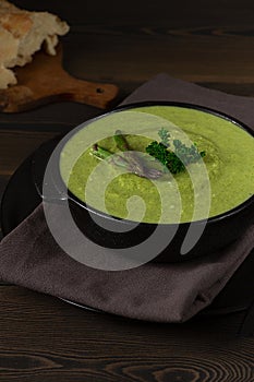 Cream soup, green asparagus, on a wooden background, healthy food, vertical, no people,