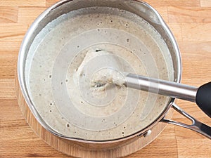 Cream soup in a pan. Blender portion in the soup. Grind puree soup ingredients
