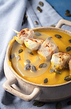 Cream soup with pumpkin and chicken skewers. Autumn healthy food