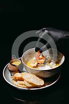 Cream soup with shrimp in hand