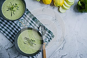 Cream soup with zucchini and basil and bread crumbs on a light background. Space for text