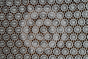 Cream white crochet lacy fabric on wood