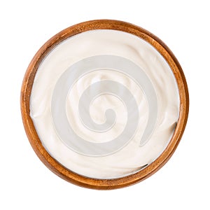 Cream yogurt, stirred with 10 percent fat content, in a wooden bowl