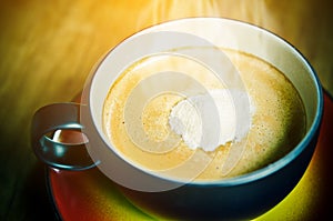 Creamer on top a cup of hot coffee.