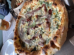 Creamy bacon and spinach pizza freshly baked from the oven