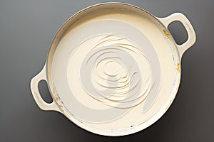 A creamy béchamel sauce by placing it on a light, cream-colored background