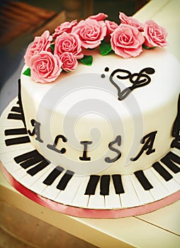Creamy cake with piano keys, treble clef and roses photo