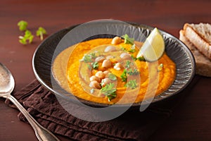 Creamy carrot chickpea soup on dark rustic background