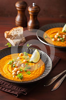 Creamy carrot chickpea soup on dark rustic background