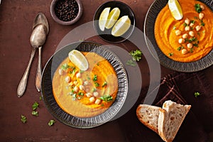 Creamy carrot chickpea soup on dark rustic background