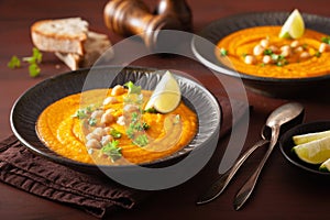 Creamy carrot chickpea soup on dark rustic background