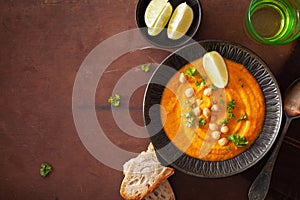 Creamy carrot chickpea soup on dark rustic background