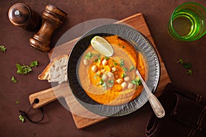 Creamy carrot chickpea soup on dark rustic background