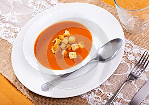 Creamy carrot soup garnished with crispy toasted bread