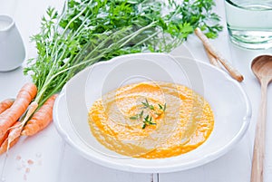 Creamy Carrot Soup on white wooden background