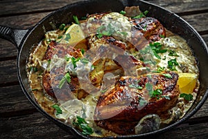 Creamy chicken fellets supremes in mushroom sauce with parsley In rustic cast iron skillet.