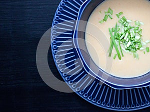 Creamy chicken soup puree in a dark blue bowl top view