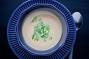 Creamy chicken soup puree in a dark blue bowl top view
