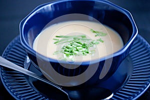 Creamy chicken soup puree in a dark blue bowl top view