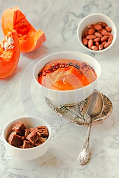 Creamy and delicious soup from roasted pumpkin with chili flakes pepper and rye crispy toast. Vegetarian autumn comfort food