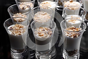 Creamy dessert of nuts in a glass stack on a dark background