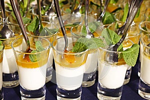 Creamy dessert and salted caramel ice cream in glass jars with fresh mint.