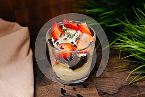 Creamy dessert with strawberries and chocolate chips in a glass