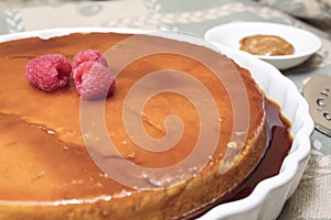 Creamy Flan dessert served with raspberries and dulce de leche