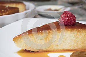 Creamy Flan dessert served with raspberries and dulce de leche