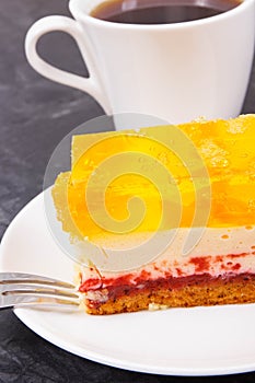 Creamy fruit cake with jelly and cup of coffee for different occasions. Festive dessert