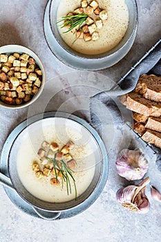 Creamy garlic soup topped with croutons and chives