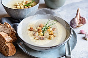 Creamy garlic soup topped with croutons and chives