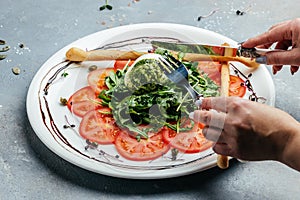 Creamy italian burrata cheese served with omatoes, fresh arugula and green pesto. Salad with traditional italian burrata cheese