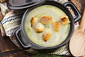 Creamy Jerusalem artichoke soup on wooden background