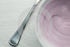 Creamy naturally colored rasberry fruit yogurt in white glass bo