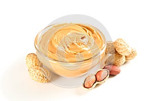 Creamy peanut butter in glass bowl and peanut  on white background
