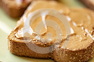 Creamy peanut butter spread on healthy whole wheat toast