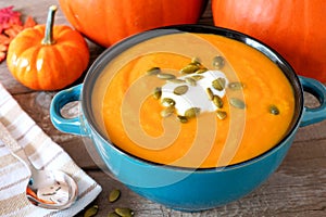 Creamy pumpkin soup in a blue bowl close up