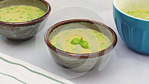 Creamy pureed celery soup with fresh green peas and fresh basil.