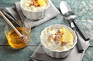 Creamy rice pudding with walnuts and orange slices in ramekins served