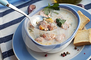 Creamy salmon soup Kalakeitto in blue bowl and spoon