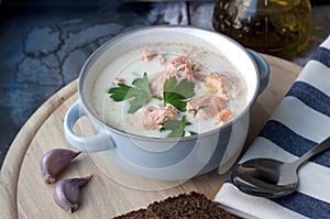 Creamy salmon soup Kalakeitto in blue bowl with spoon