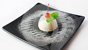 Creamy souffle on a black plate with a cherry